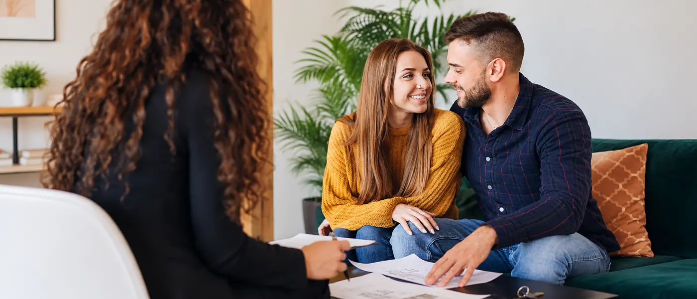 Newlywed couple discussing mortgage pre-approval for their homebuyer program with Nicola Aulds Realty