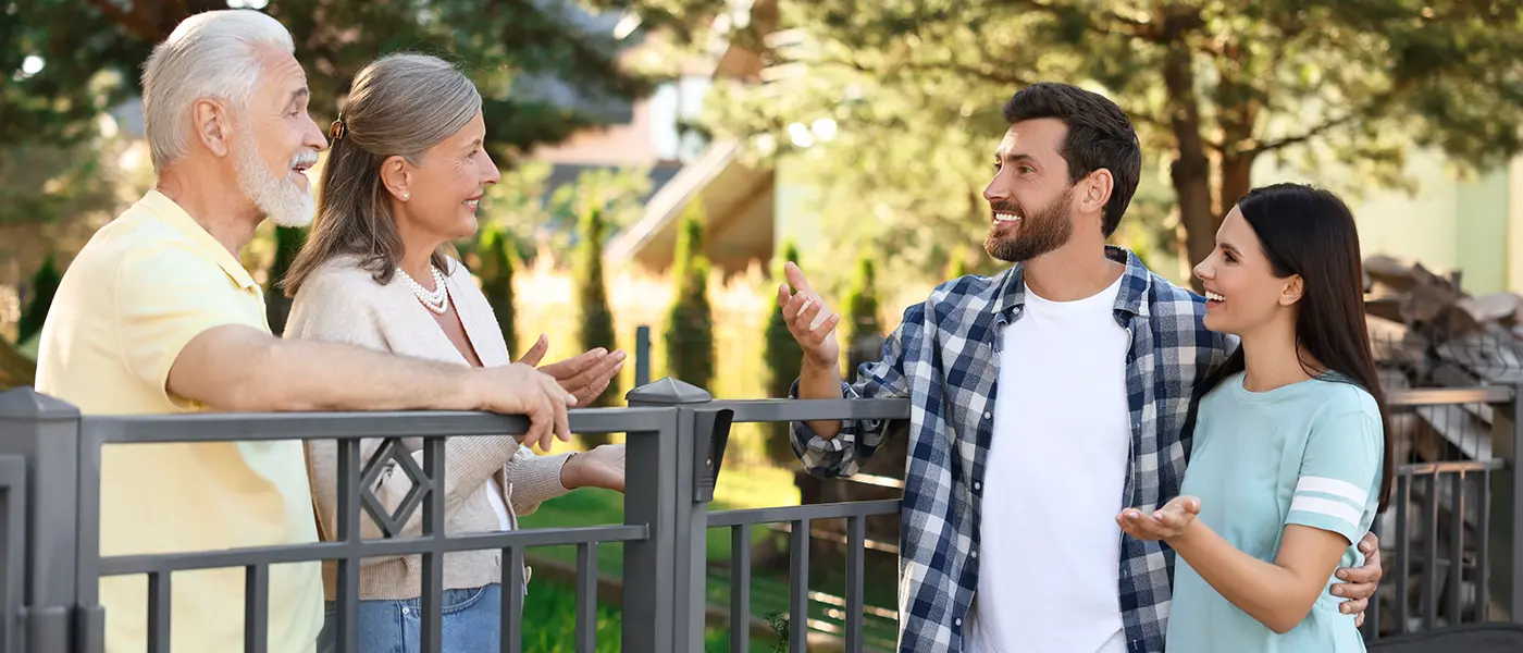 Young couple talking to older neighbor couple about home buying offer