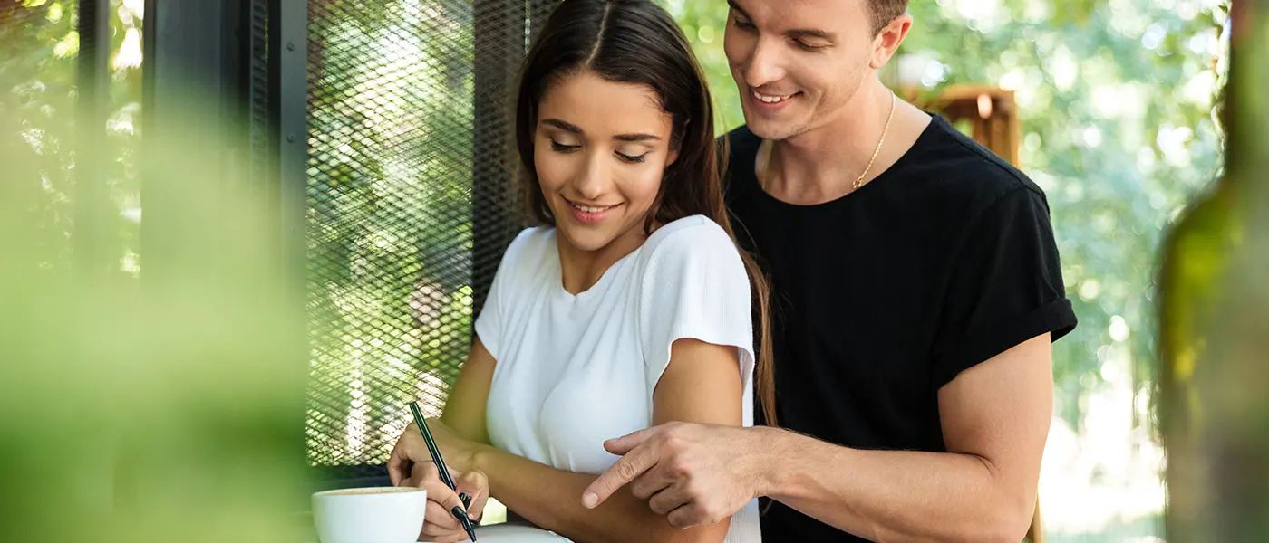 Happy smiling young couple making their home buying wish list